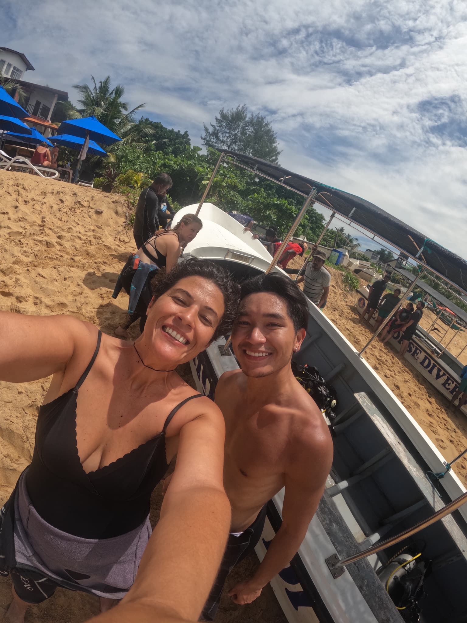 Two happy guests taking a selfie beside the dive boat on Unawatuna Beach